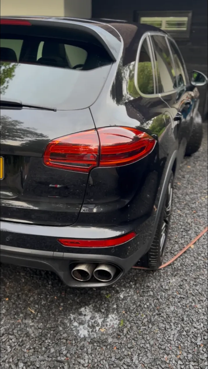 Glanzende zwarte Porsche SUV na mobiele autowas en detailing
