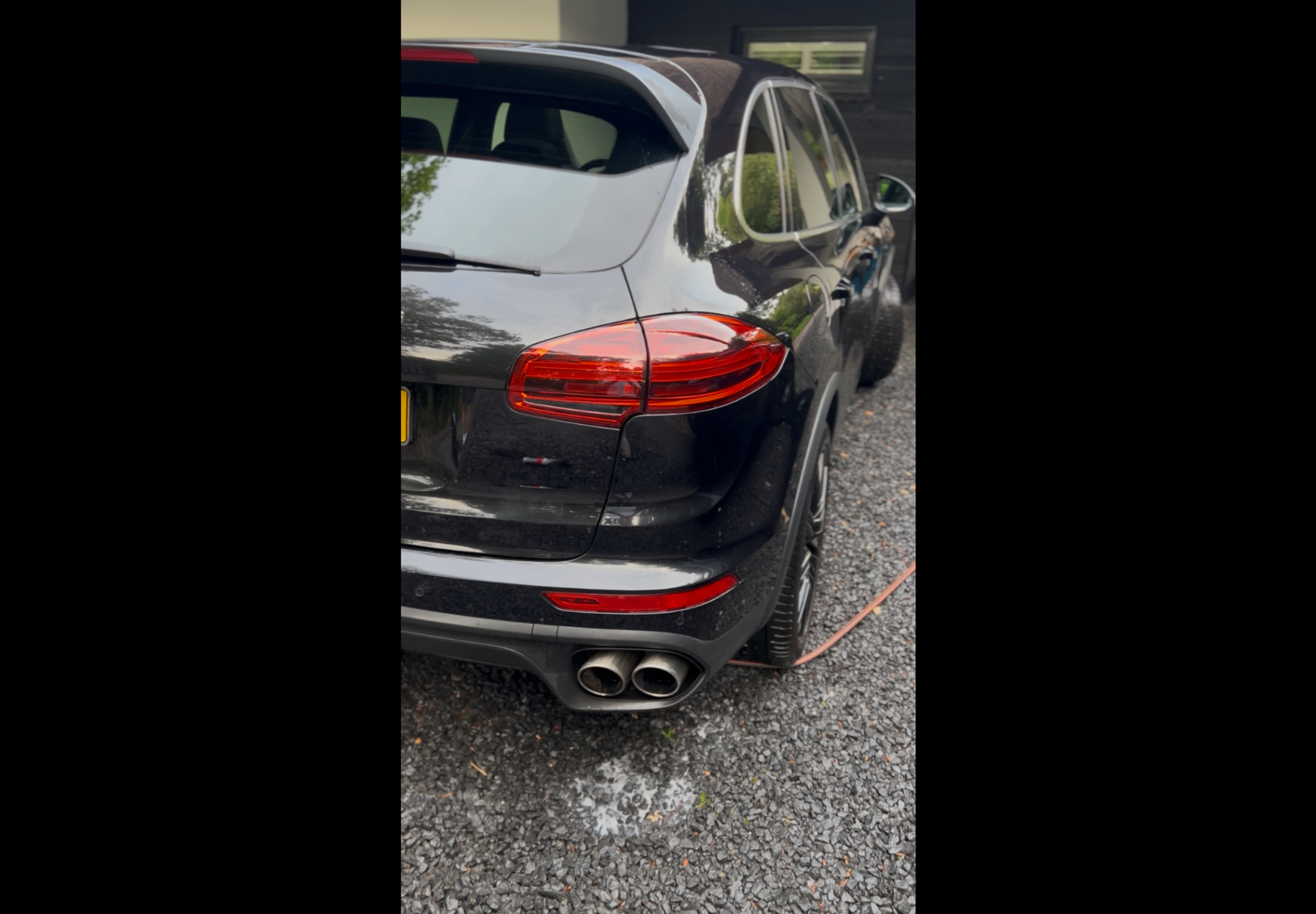 Glanzende zwarte Porsche SUV na mobiele autowas en detailing